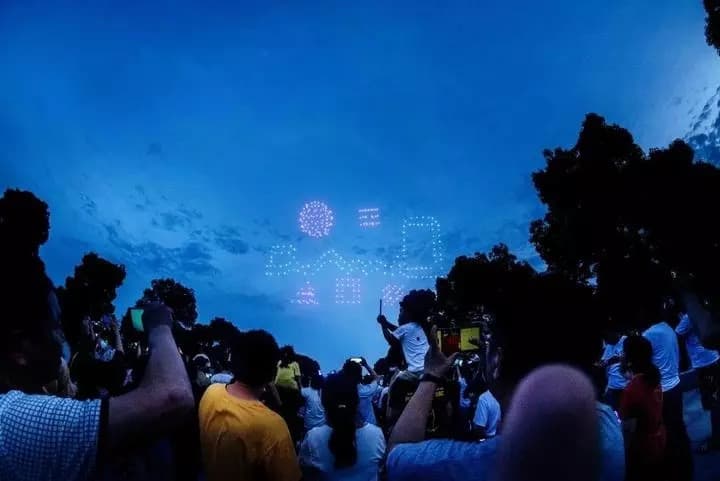 观众观看夜间无人机表演